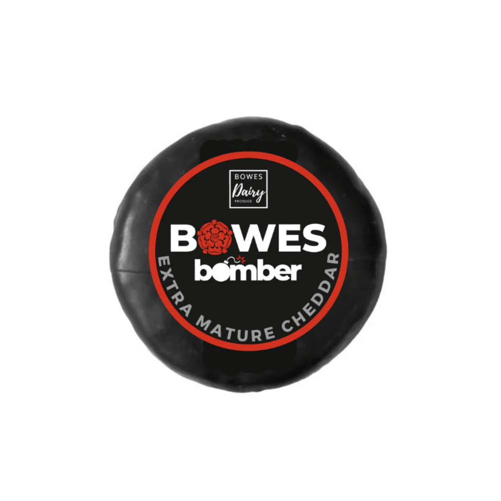 Bowes Bomber Extra Mature Cheddar cheese round with black wax coating, ideal for gourmet cheese selections.
